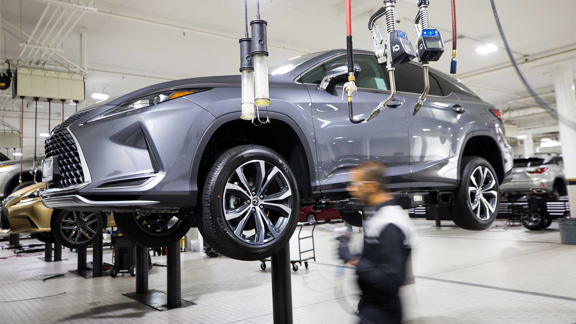 Inside of a Lexus service centre with a car on a hoist